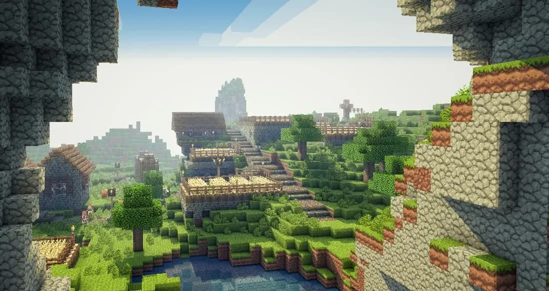 Un pueblo de Minecraft visto desde la entrada de una cueva, junto a un río
